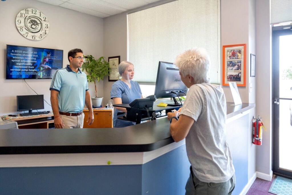 Dr. Raj and Alissa helping a patient at the front desk