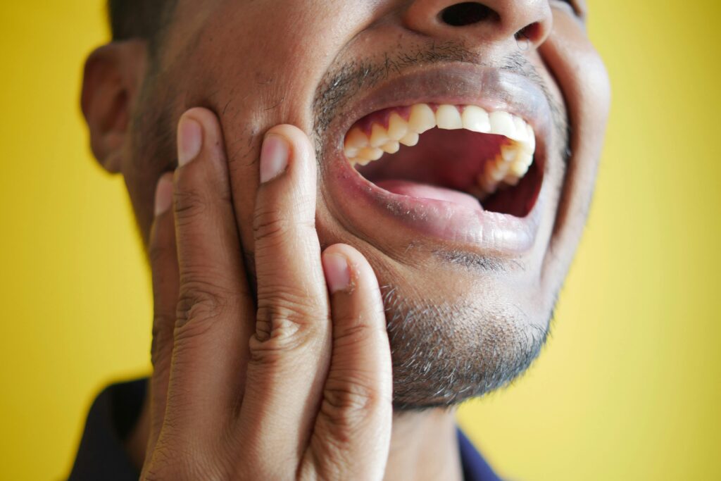 a close up of main experiencing jaw pain from TMJ disorder